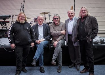 Fünf Männer in legerer Kleidung haben sich zum Gruppenbild vor der Bühne einer Rockband in der Schmöllner Ostthüringenhalleaufgestellt. Zwei der Männer sitzen auf dem Bühnenrand. Sie sind die Gesprächspartner für den Zeizeugensalon über das ehemalige Schmöllner Kulturhaus „Esse“.